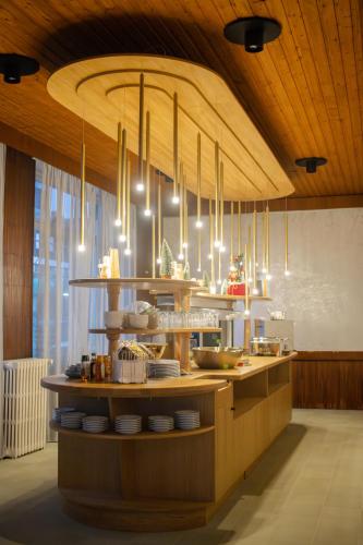 a kitchen with a counter with plates and chandeliers at Hôtel La Réserve in Gérardmer