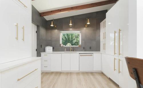 Una cocina con gabinetes blancos y una ventana. en Charming Four-Bedroom Coastal Retreat Near Neptune Beach, en Neptune Beach