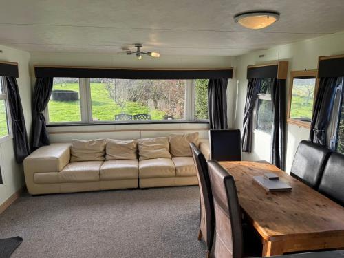 a living room with a couch and a table at The Lodge - 3BR, Woodland Forge, Garden Patio, Parking, Sleeps 6 in Over Whitacre