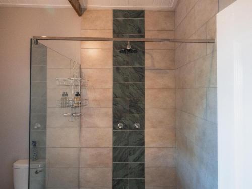 a shower with a glass door with a toilet at Barn Owl Cabin at Vrolikheid Landgoed in Tulbagh