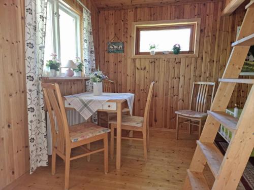 a dining room with a table and chairs in a cabin at Cozy cottage on beautiful Rossö, Orust SE09130 in Röd