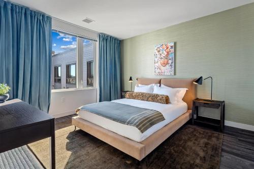 Un dormitorio con una cama y una ventana grande. en Hyatus Luxury Residences Boston South Bay Designer Collection, en Boston