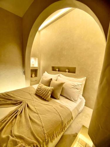 a bedroom with a large bed with an arch above it at Riad Oum h&N in Marrakesh