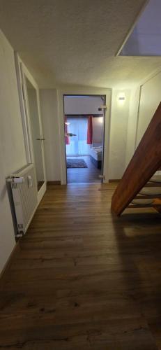 an empty room with a wooden floor and a hallway at Ferienwohnung "Dachblick" Bad Elster in Bad Elster
