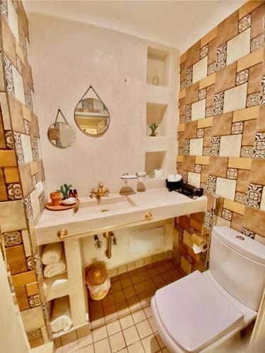 a bathroom with a white toilet and a sink at Riad Oum h&N in Marrakesh