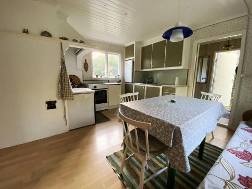 a kitchen and dining room with a table and chairs at Cottage with Private Shoreline in Boxvik SE09128 in Nösund