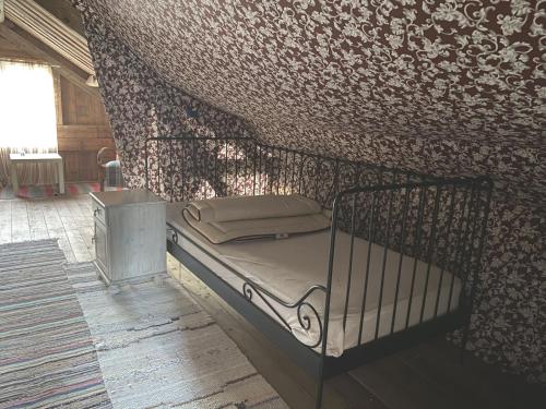 a small bed in a room with a wall at Cottage with Private Shoreline in Boxvik SE09128 in Nösund