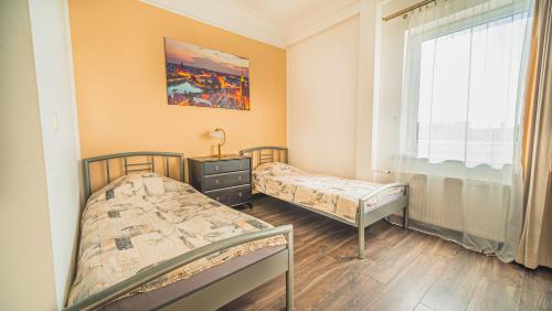 deux lits dans une chambre avec fenêtre dans l'établissement Apartamenty Wratislavia, à Wrocław