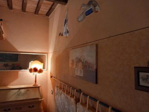 Agriturismo Il Maggio - Manciano في مانشانو: غرفة بها جدار عليه بعض الطيور