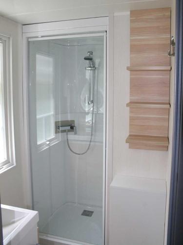 a shower with a glass door in a bathroom at Camping l'île Cariot in Chaillé-les-Marais