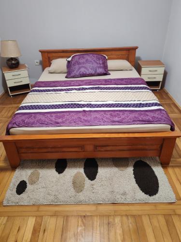 a bed in a room with two night stands and a rug at Signorina in Smederevo