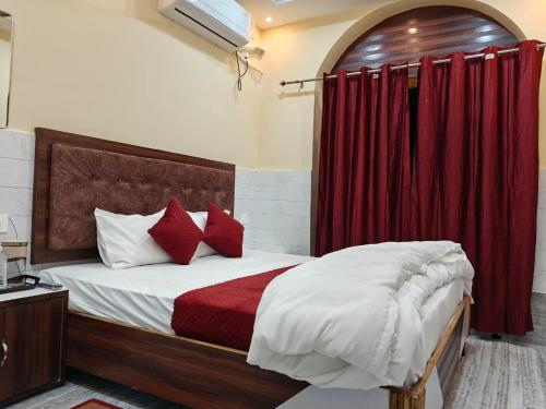 een slaapkamer met een bed met rode gordijnen bij Shree Gopal Inn in Varanasi