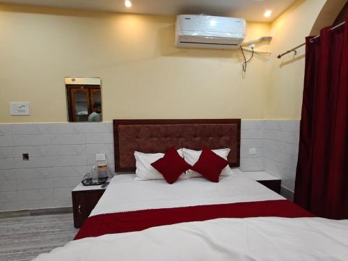 een slaapkamer met een bed met rode en witte kussens bij Shree Gopal Inn in Varanasi