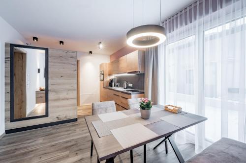 a dining room with a table and a kitchen at MYALPS Jordans Lodge in Längenfeld