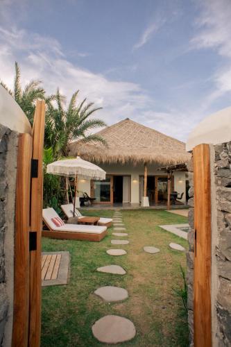 a resort with a lawn with stepping stones in the yard at Irama Surf Villas - Private Pool Villas at Yoyos in Sekongkang