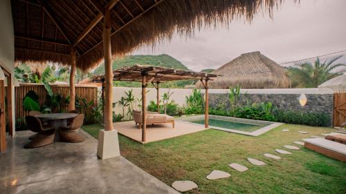 un complejo con piscina, silla y sombrilla en Irama Surf Villas, en Sekongkang Bawa
