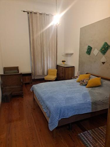 um quarto com uma cama com lençóis azuis e almofadas amarelas em Camera Privata Vicino al Teatro Ariston em Sanremo