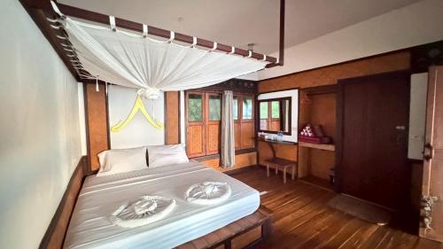 a bedroom with a bed and a desk at Le Dugong Libong Resort in Ko Libong