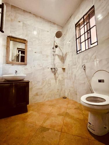 a bathroom with a toilet and a sink at Cj VILLA in Karatu