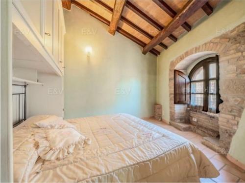 ein Schlafzimmer mit einem großen Bett in einem Gebäude in der Unterkunft la casa nel borgo in Bevagna