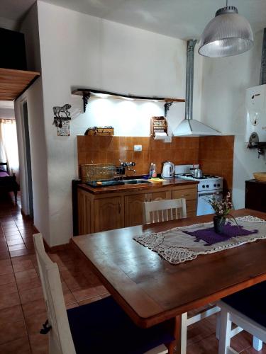 eine Küche mit einem Holztisch und eine Küche mit einem Herd in der Unterkunft Casa en Nono in Nono