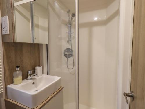 a bathroom with a sink and a shower at Foxwood Hideaway in Carnforth