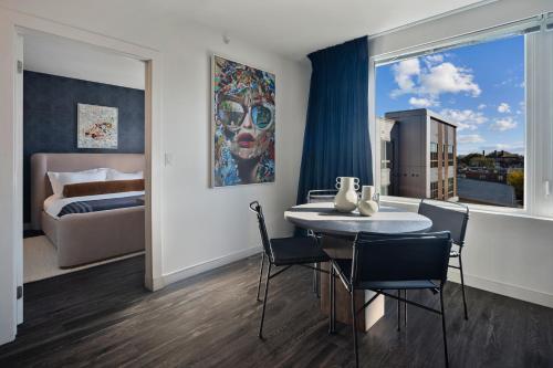 a room with a table and chairs and a bed at Hyatus Luxury Residences Boston South Bay Designer Collection in Boston