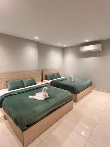 カイロにあるFanton Hotelのベッド2台(緑のシーツ付)