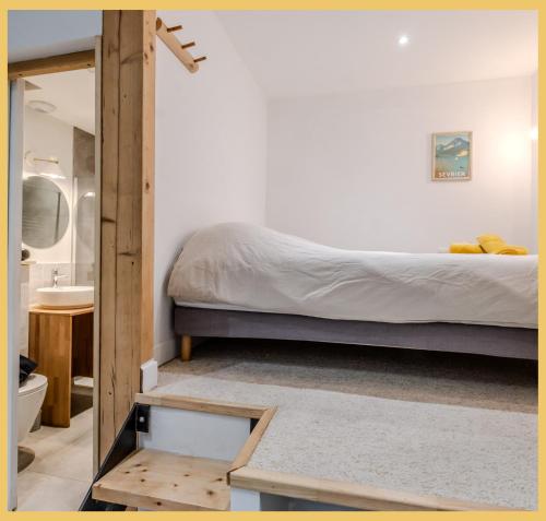 a bedroom with a bed and a sink and a mirror at L'Ecrin du Lac I Studio I Sévrier in Sévrier
