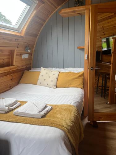Mill House Farm Pods - Lapwing Lodge في Pilling: سرير كبير في غرفة مع نافذة
