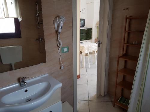 ヴェーリエにあるCasavacanze Salento Spaniのバスルーム(洗面台付)、壁掛け電話