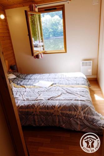 a bed in a bedroom with a window at Gîte 19G5412 in Soursac