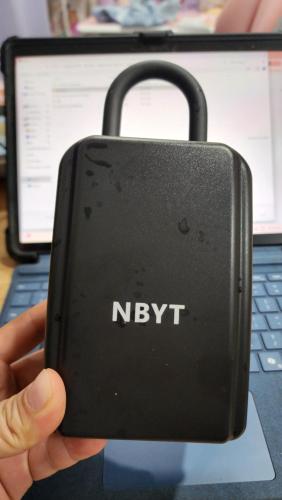 a person holding up a laptop computer with a key pad at Place to stay kuching 