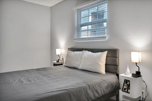 a bedroom with a bed with two lamps and a window at Black And White 1 BR by Ryan Korban in Durham