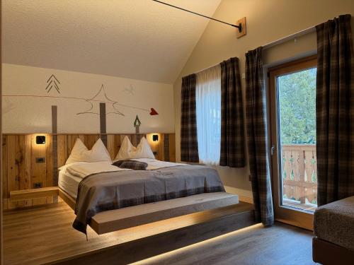 a bedroom with a bed and a window at Albergo Centrale in San Martino di Castrozza