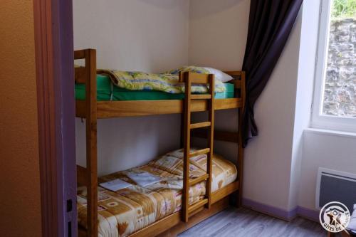 two bunk beds in a room with a window at Gite ecole in Soursac
