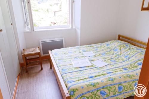 Un dormitorio con una cama en una habitación con ventana. en Gite ecole, en Soursac