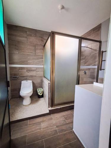 a bathroom with a toilet and a shower at Hotel Zepeda in Ocosingo