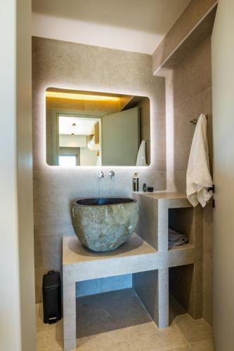 a bathroom with a bowl sink and a mirror at Anemelia Villas in Karpathos