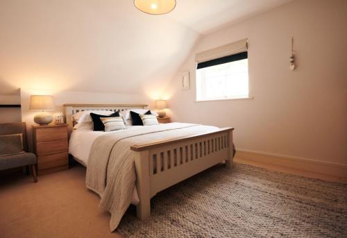 a bedroom with a large bed and a window at Footprints - gorgeous coastal apartment with sea views in Saundersfoot