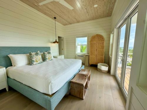a bedroom with a large bed and a large window at Kalopsia Seaside Villas & Marina in Great Guana Cay