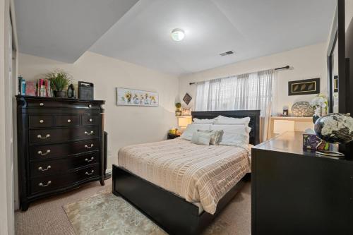 a bedroom with a large bed and a dresser at Fireplace • Grill • Gym‑Ready • Near Bull Run in Centreville