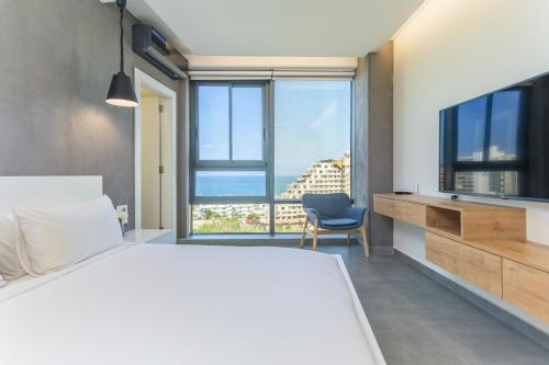 una camera da letto con un letto grande e una grande finestra di Germac Suites a Al Kaslīk