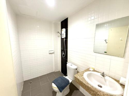 Un baño con lavabo, inodoro y espejo. en Easy Life R2, en Patong Beach