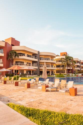 a resort with chairs and umbrellas and a pool at Playa Grande Condominium in El Coco