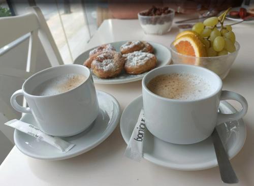 アムーダラ・イラクリオンにあるCastro Hotelのコーヒー2杯、ドーナツプレート(テーブル上)