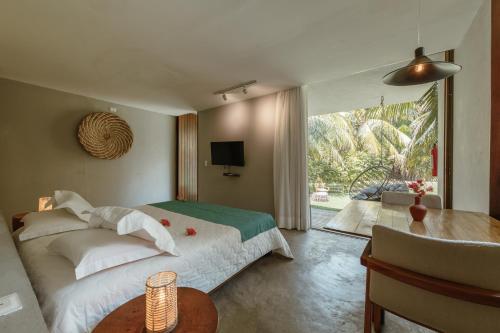 a bedroom with a bed and a large window at Villas Taturé in São Miguel dos Milagres