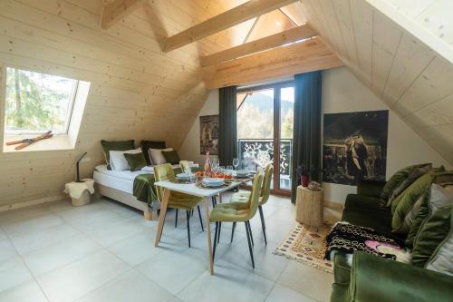 ein Wohnzimmer mit einem Bett und einem Tisch und Stühlen in der Unterkunft Jaszczurówka 33 Aparthotel & SPA in Zakopane
