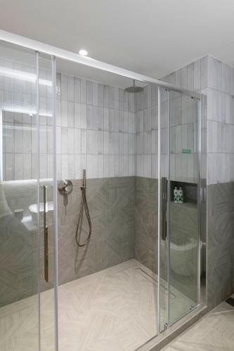 a shower with a glass enclosure in a bathroom at PAREA Athens in Athens
