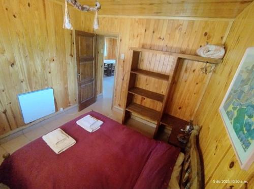 a bedroom with a bed in a wooden room at Cabañas Viña Aliwen in Vistalba